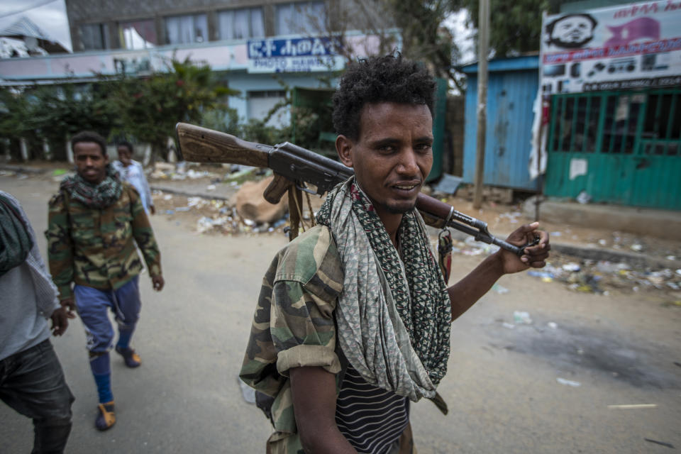 FILE - In this Friday, May 7, 2021 file photo, fighters loyal to the Tigray People's Liberation Front (TPLF) walk along a street in the town of Hawzen, then-controlled by the group, in the Tigray region of northern Ethiopia. The leader of the Oromo Liberation Army armed group that Ethiopia's government has designated a terrorist organization says his group has struck a military alliance with the Tigray forces, in an interview on Wednesday, Aug. 11, 2021. (AP Photo/Ben Curtis, File)