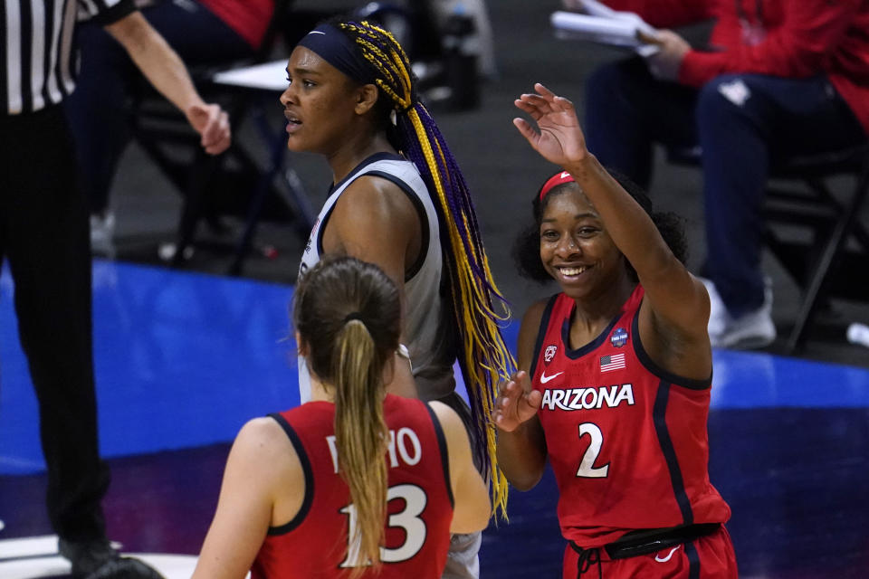 Arizona guard Aari McDonald (2) celebrates with teammate guard Helena Pueyo (13) in front of Connecticut forward Aaliyah Edwards after getting fouled during the second half of a women's Final Four NCAA college basketball tournament semifinal game Friday, April 2, 2021, at the Alamodome in San Antonio. (AP Photo/Eric Gay)