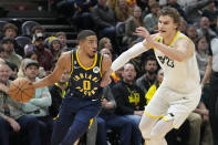 Indiana Pacers guard Tyrese Haliburton (0) drives to the basket as Utah Jazz's Lauri Markkanen (23) defends during the first half of an NBA basketball game Friday, Dec. 2, 2022, in Salt Lake City. (AP Photo/Rick Bowmer)