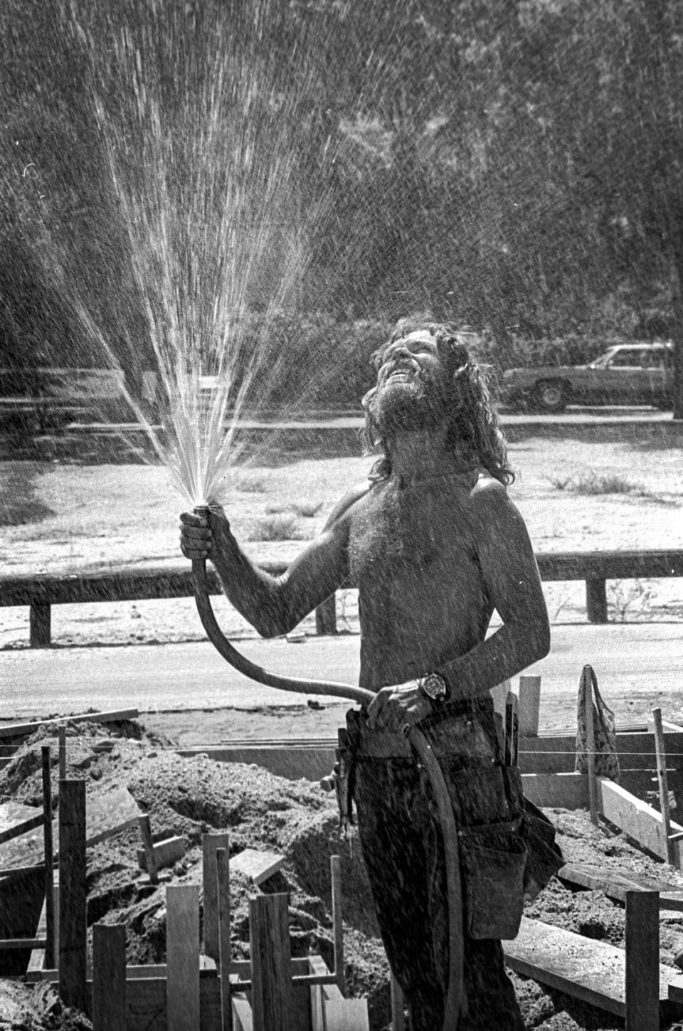 Glenn Clark gives himself a cool shower during work on a construction site in Paso Robles as the temperatures continued in the 100s as seen here on June 25, 1976.