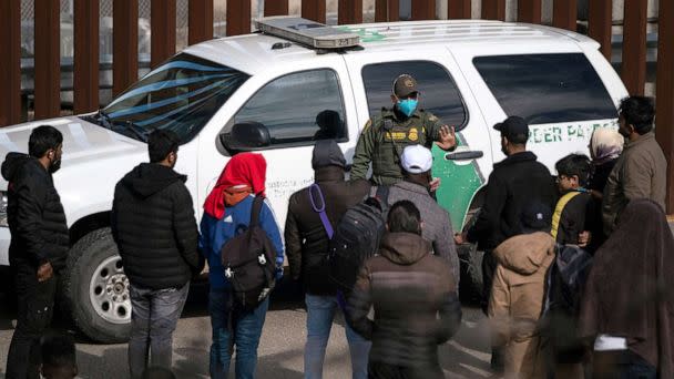 PHOTO: A border patrol agent talks to a group of migrants, mostly from African countries, before processing them after they crossed the US-Mexico border, taken from Tijuana, Baja California state, Mexico, on Nov. 11, 2022. (Guillermo Arias/AFP via Getty Images)