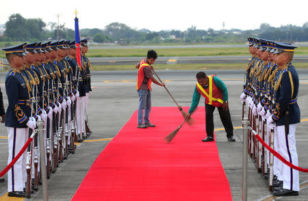 Workers sweep the red carpet in preparations for the arrival of Japanese Prime Minister Shinzo Abe and his wife Akie Abe for a state visit in metro Manila, Philippines January 12, 2017. REUTERS/Romeo Ranoco