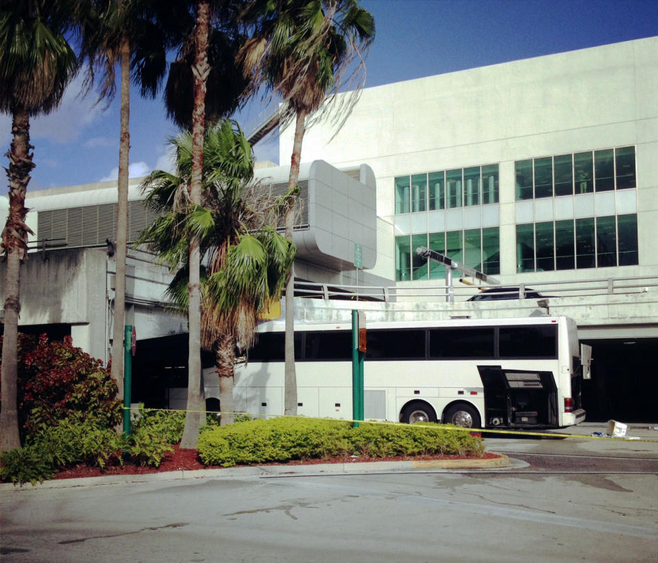 A bus is lodged into an overpass at the Miami International Airport on Saturday, Dec. 1, 2012. The vehicle was carrying over 30 people when it crashed into the structure. Authorities say buses typically are routed through the departures area, which has a higher clearance. (AP Photo/Suzette Laboy)