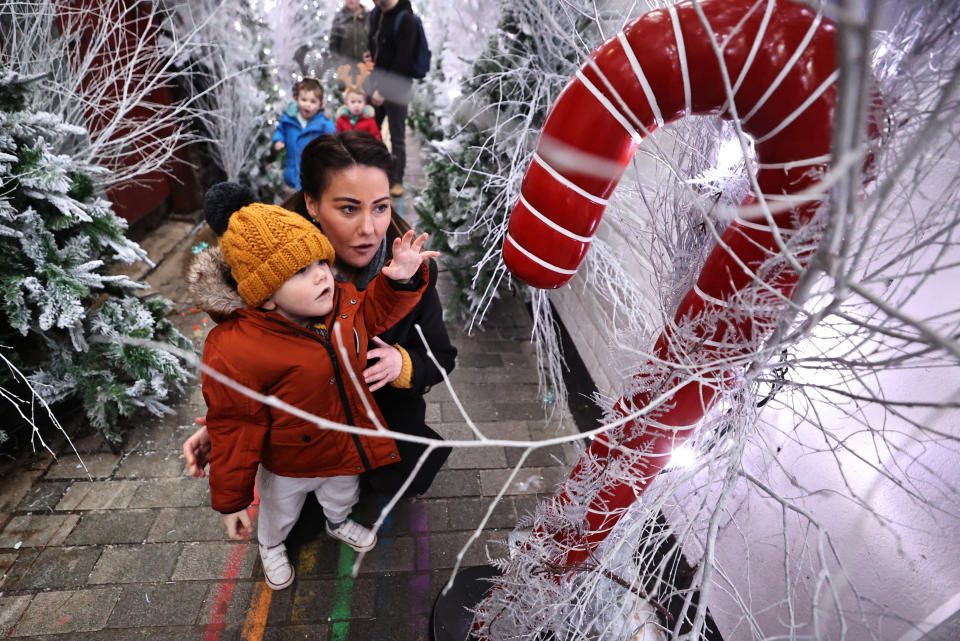 Two year old Antoin McCready walking through The Jailhouse Christmas Magic on Joy's Entry in Belfast with his mother Patricia Williamson. (Photo by Liam McBurney/PA Images via Getty Images)