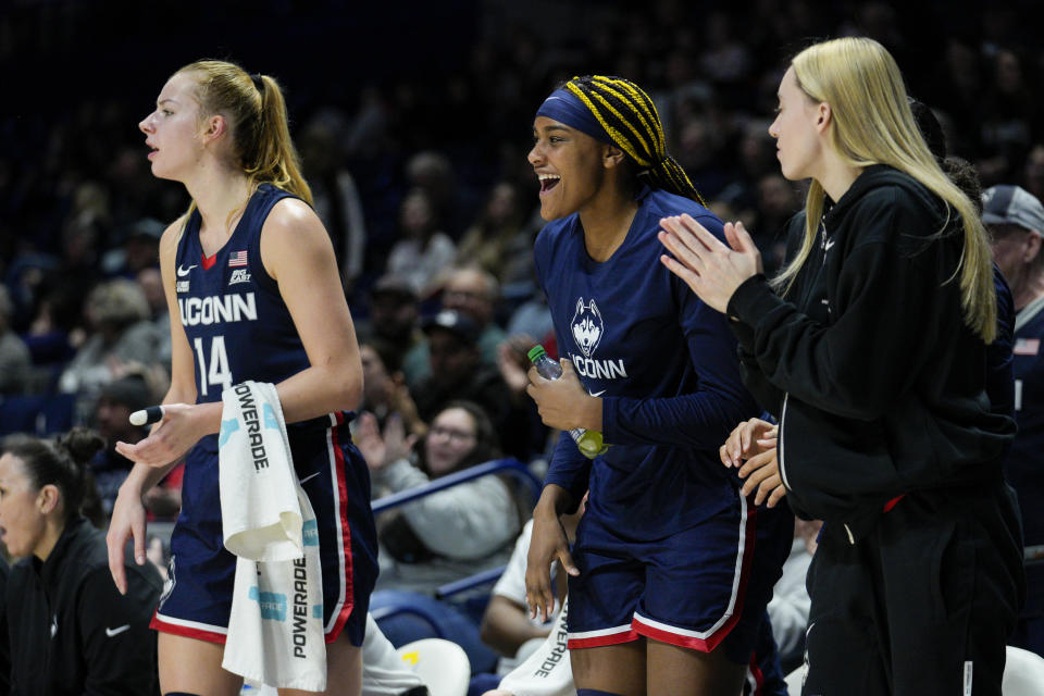 UConn's Dorka Juhasz (14) and Aaliyah Edwards, center, cheer from the bench during the second half of an NCAA college basketball game against Xavier, Thursday, Jan. 5, 2023, in Cincinnati. (AP Photo/Jeff Dean)