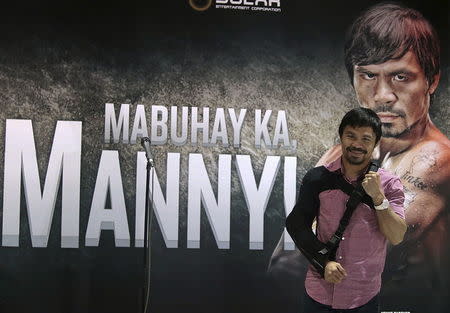 Boxer Manny Pacquiao poses for the members of the media upon his arrival at the international airport in Manila May 13, 2015. REUTERS/Romeo Ranoco