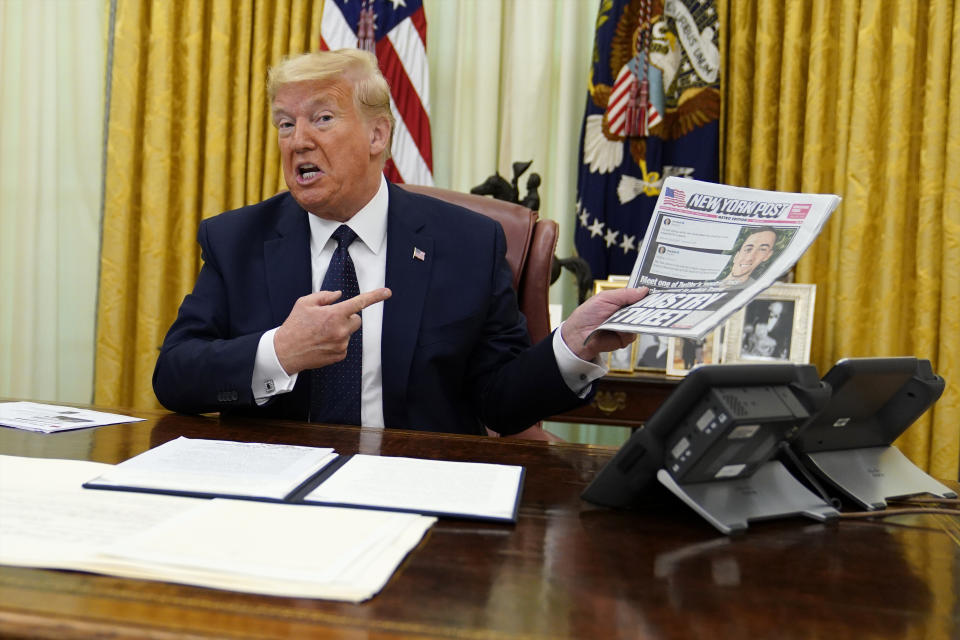 President Donald Trump holds up a copy of the New York Post as speaks before signing an executive order aimed at curbing protections for social media giants, in the Oval Office of the White House, Thursday, May 28, 2020, in Washington. (AP Photo/Evan Vucci)