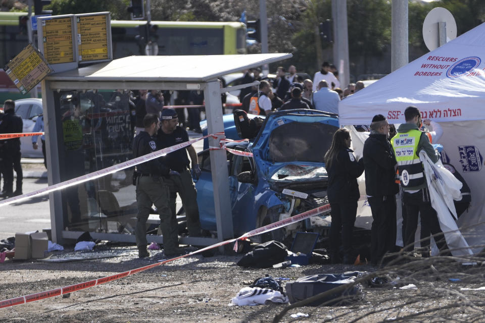 Members of Zaka Rescue and Recovery , and Israeli police forensic team work at the site of a car-ramming attack at a bus stop in Ramot, a Jewish settlement in east Jerusalem, Friday, Feb. 10, 2023. A suspected assailant rammed his car into several pedestrians in east Jerusalem on Friday. Police said that the suspected attacker was shot at the scene. There was no immediate word on his condition. Police identified the ages of the injured children as 5 and 6. (AP Photo/Mahmoud Illean)