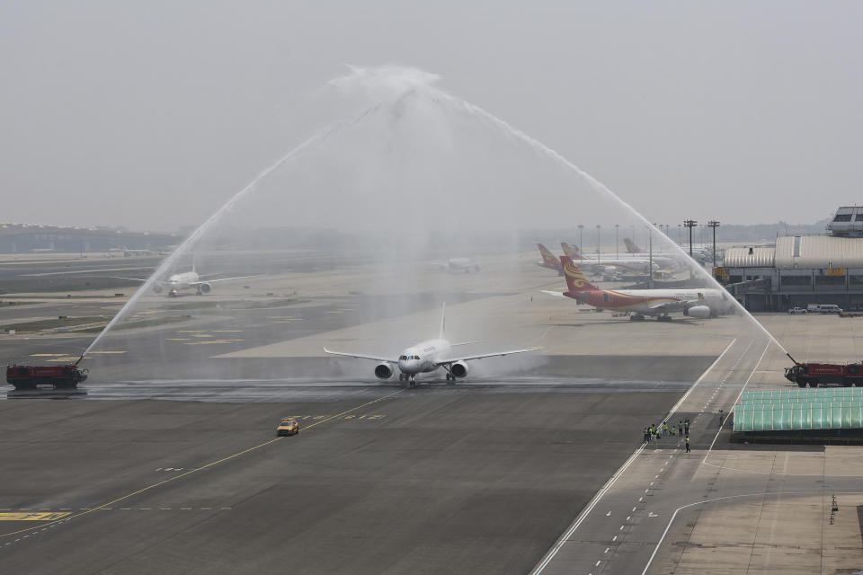 In this photo released by Xinhua News Agency, a C919 plane, China's first domestically made passenger jet is welcomed with water jets after completing its maiden commercial flight operated by China Eastern Airlines at the Beijing Capital International Airport in Beijing on Sunday, May 28, 2023. China’s first domestically made passenger jet flew its maiden commercial flight on Sunday, as China looks to compete with industry giants such as Boeing and Airbus in the global aircraft market. (Wei Meng/Xinhua via AP)