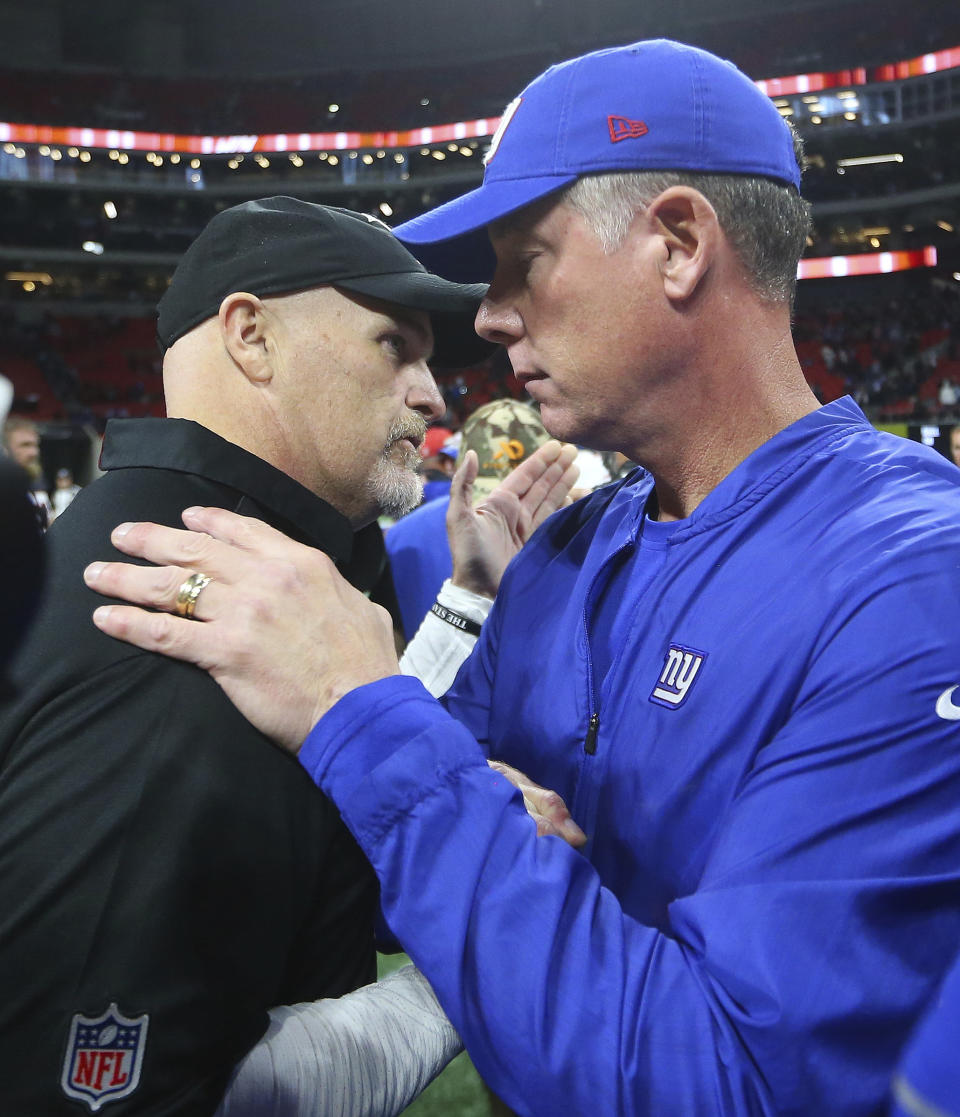 Atlanta Falcons head coach Dan Quinn, left, speaks with New York Giants head coach Pat Shurmur after an NFL football game, Monday, Oct. 22, 2018, in Atlanta. The Atlanta Falcons won 23-20. (AP Photo/John Bazemore)