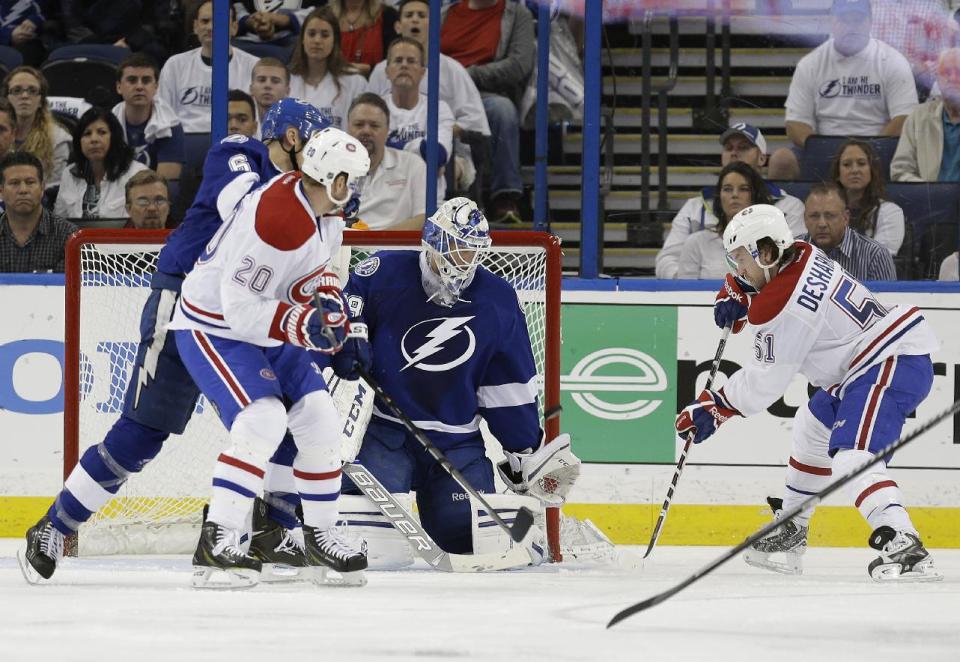 CORRECTS TO SECOND PERIOD NOT FIRST PERIOD - Montreal Canadiens center David Desharnais (51) fires the puck past Tampa Bay Lightning goalie Anders Lindback (39), of Sweden, for a goal during the second period of Game 2 of a first-round NHL hockey playoff series on Friday, April 18, 2014, in Tampa, Fla. Canadiens' Thomas Vanek (20) and Lightning's Sami Salo (6), of Finland, look on. (AP Photo/Chris O'Meara)