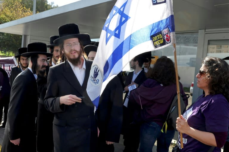 Des manifestants et des juifs orthodoxes devant un bureau de recrutement de l’armée dans la ville de Kiryat Ono, près de Tel Aviv, le 5 mars 2024, lors d’une manifestation contre leur exemption du service militaire (JACK GUEZ)