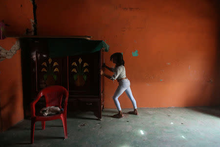 Natashia, 19, an indigenous Zapotec transgender woman also know as Muxe, moves a furniture inside her house destroyed after an earthquake that struck on the southern coast of Mexico late on Thursday, in Juchitan, Mexico, September 10, 2017. REUTERS/Edgard Garrido