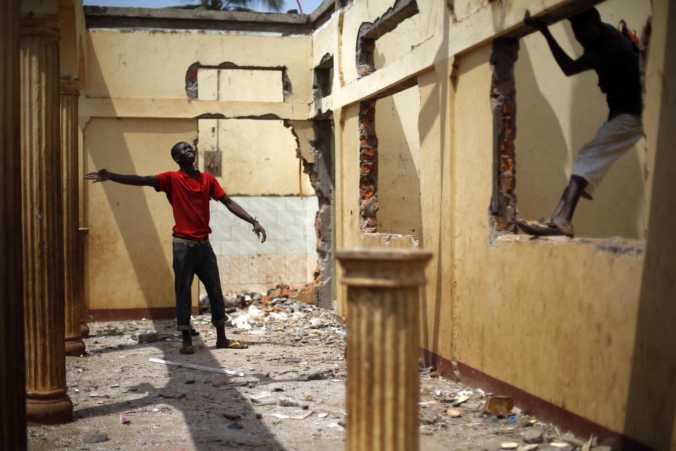 Looters dismantle the house belonging to a Muslim man who fled the night before in Bangui, Central African Republic, Monday Feb. 3, 2014. Fighting between Muslim Seleka militias and Christian anti-Balaka factions continues as French and African Union forces struggle to contain the bloodshed. (AP Photo/Jerome Delay)