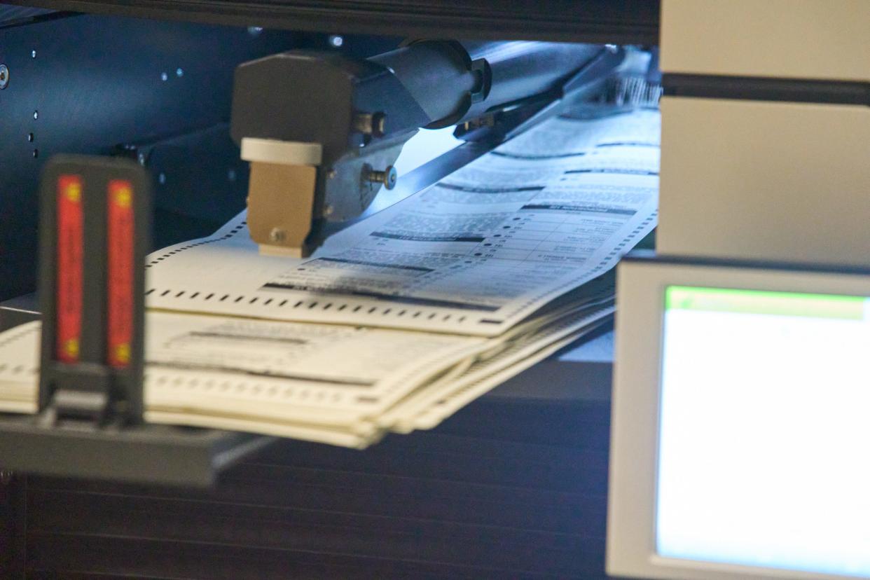 Ballots are run through a machine as tabulators work to process ballots at the Maricopa County Tabulation and Election Center in Phoenix, on Saturday, Nov. 12, 2022.