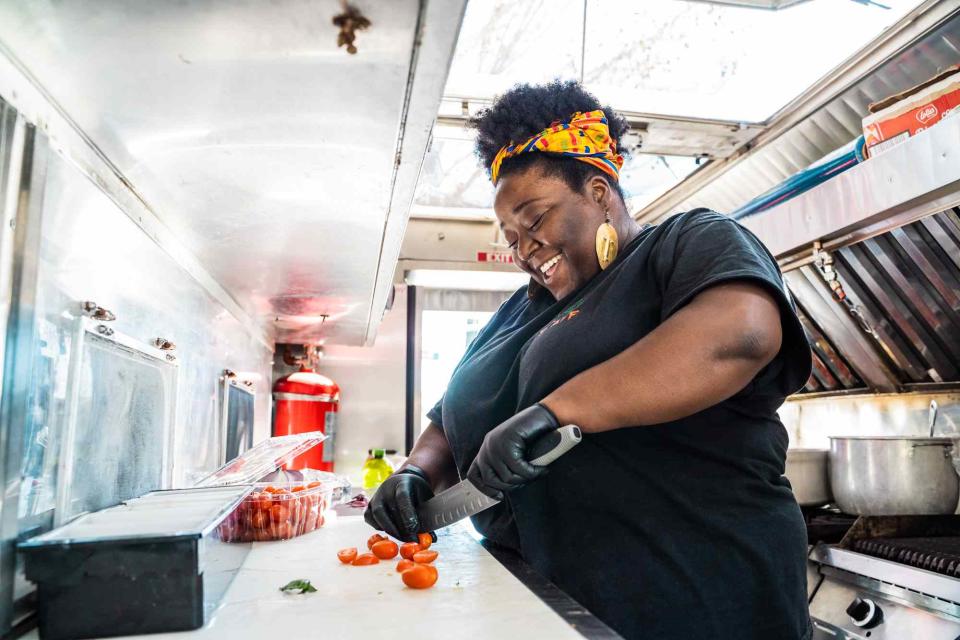 Rheema Calloway chopping tomatoes in the Vegan Hood Chefs food truck.