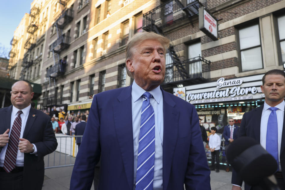 Former president Donald Trump, talks to members of the media while visiting a bodega, Tuesday, April 16, 2024, who's owner was attacked last year in New York. Fresh from a Manhattan courtroom, Donald Trump visited a New York bodega where a man was stabbed to death, a stark pivot for the former president as he juggles being a criminal defendant and the Republican challenger intent on blaming President Joe Biden for crime. Alba's attorney, Rich Cardinale, second from left, and Fransisco Marte, president of the Bodega Association, looked on. (AP Photo/Yuki Iwamura)