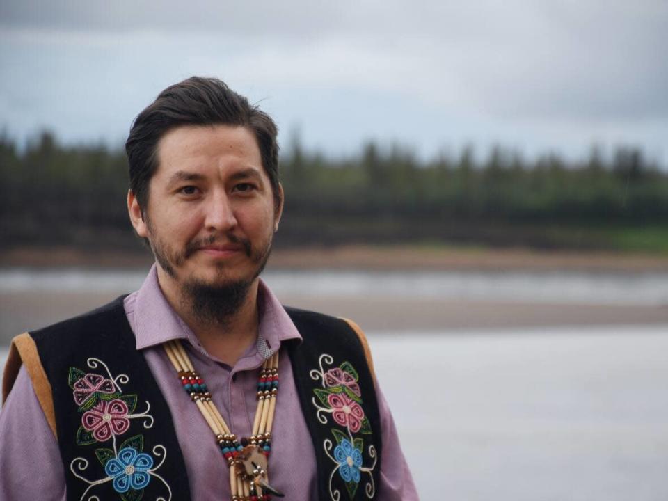 Vuntut Gwitchin First Nation Chief Dana Tizya-Tramm poses for a photo in front of the Porcupine River in Old Crow on July 22. (Jackie Hong/CBC - image credit)