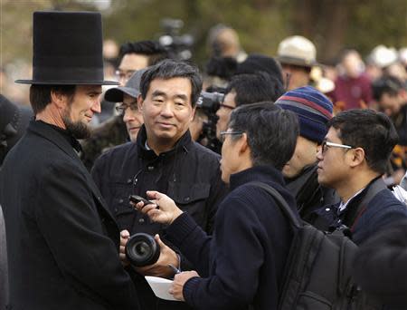 A re-enactor portraying U.S. President Abraham Lincoln (L) is interviewed by Japanese journalists at the Gettysburg National Cemetery in Pennsylvania November 19, 2013, the burial ground for Civil War Union soldiers in which U.S. President Abraham Lincoln travelled to in 1863 to deliver a few concluding remarks at a formal dedication. REUTERS/Gary Cameron