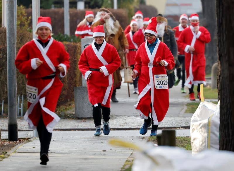 People dressed as Santa Claus race through the streets of Michendorf