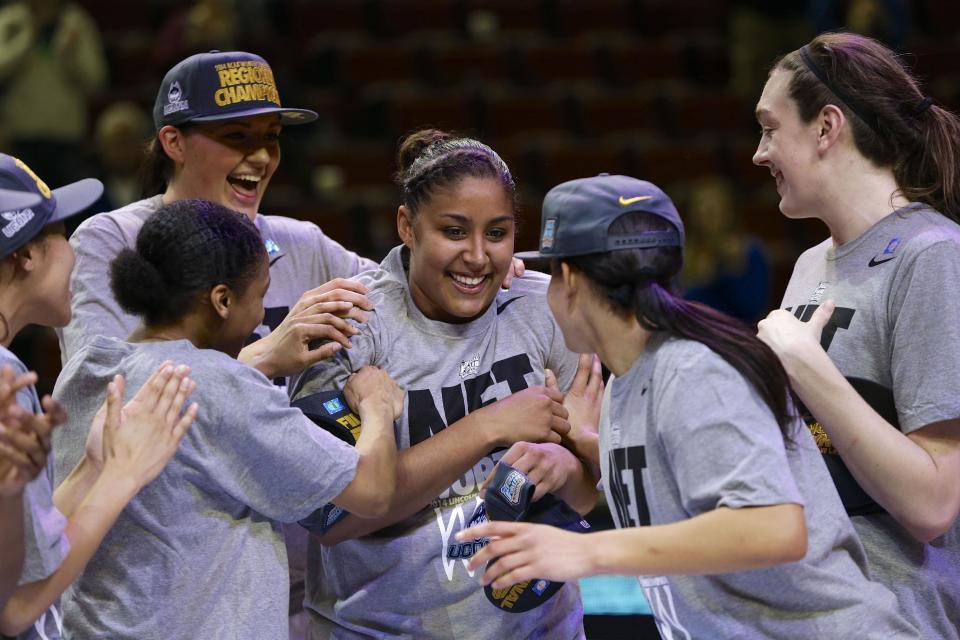 Connecticut players including Stefanie Dolson, top left, and Breanna Stewart, right, celebrate with Kaleena Mosqueda-Lewis, center, after beating Texas A&M, 69-54 in the Lincoln regional final game in the NCAA college basketball tournament in Lincoln, Neb., Monday, March 31, 2014. Connecticut advances to the final four. (AP Photo/Nati Harnik)