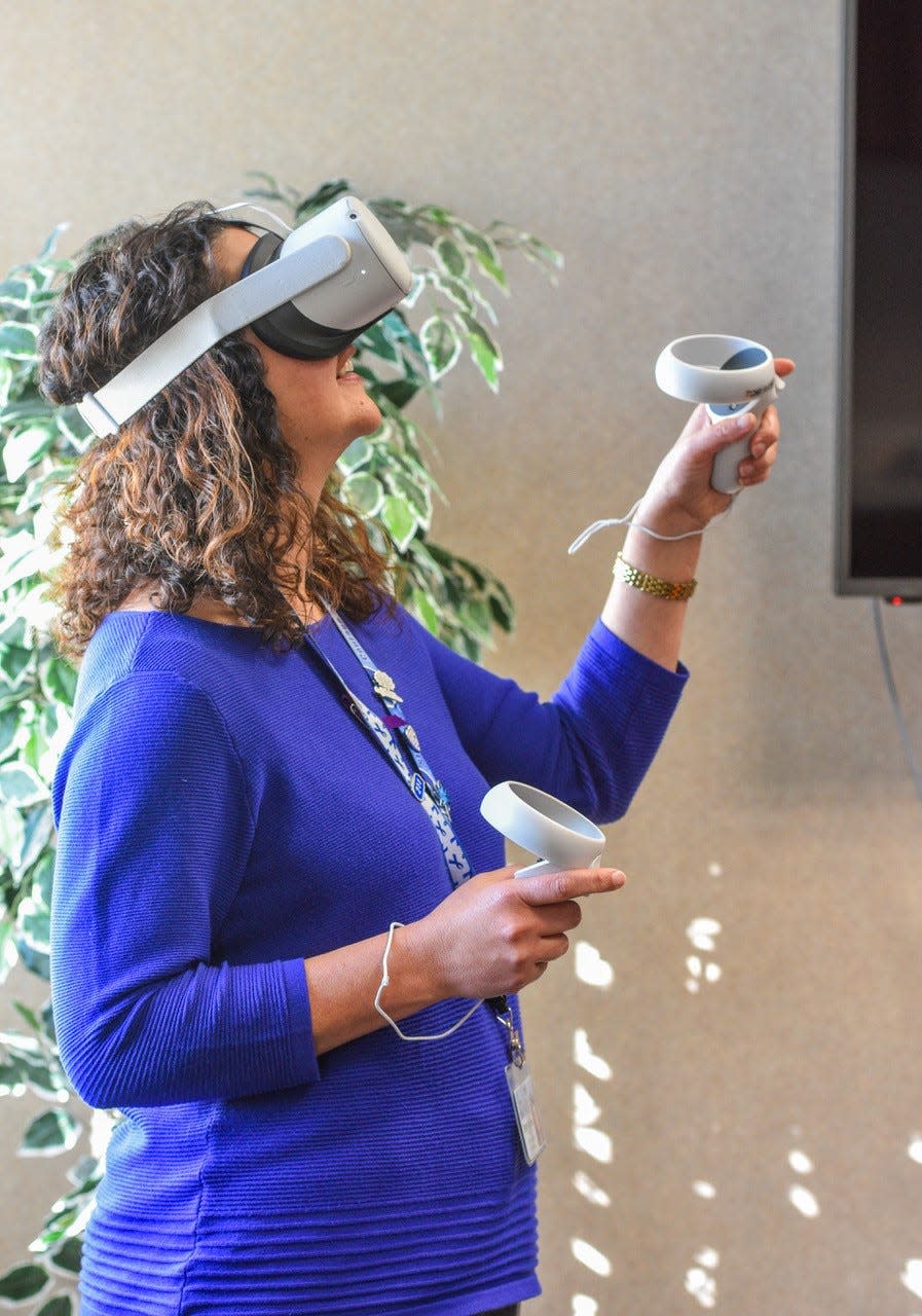 Stephanie Kowal, director of Ottawa County Department of Job and Family Services, demonstrates the Virtual Reality equipment that she uses to train staff who will be involved with Children’s Services investigations.