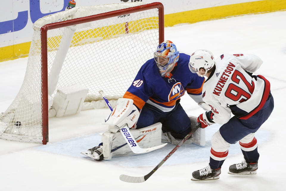 Washington Capitals center Evgeny Kuznetsov (92) and New York Islanders goaltender Semyon Varlamov (40) look into the net after Kuznesov scored in the shootout of an NHL hockey game,Thursday, April 22, 2021, in Uniondale, N.Y. The Capitals won 1-0. (AP Photo/Kathy Willens)