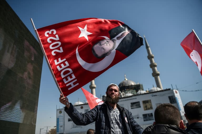 A man waves a flag with a portrait of Turkish President Recep Tayyip Erdogan on April 11, 2017 during a "yes" campaign event in Istanbul's Eminonu district