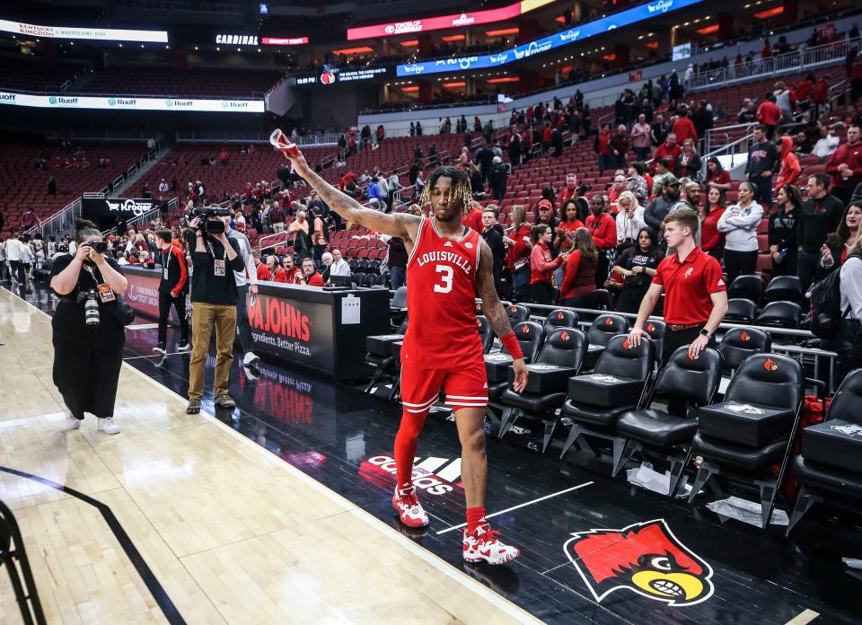 Louisville senior guard El Ellis waves to the fans remaining in the stands as he walks off the court after the Cards' 71-54 loss to Virginia Tech. Feb. 28, 2023.