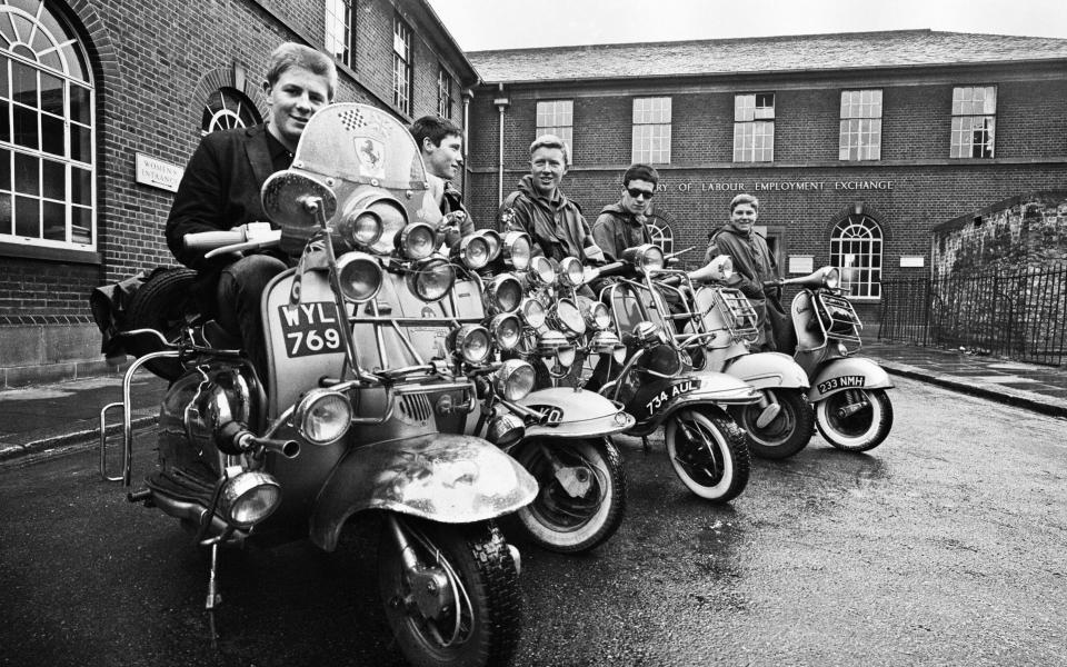 The mods and rockers were two conflicting British youth subcultures of the early to mid-1960s. Media coverage of mods and rockers fighting in 1964 sparked a moral panic about British youths, and the two groups became labelled as folk devils. John Rogers on his scooter with friends in peckham, 6th May 1964. (Photo by Cyril Maitland/Mirrorpix/Getty Images)  - Getty