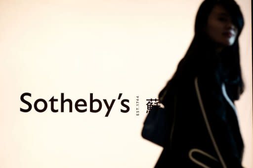 A woman walks the Sotheby's logo in Hong Kong. Sotheby's said on Monday it has cancelled the sale of a Chinese painting by a top-selling artist at its auction in Hong Kong, after its ownership was challenged by a Taiwanese Buddhist nun