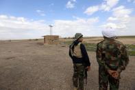 Shi'ite fighters stand with their weapons in the town of Hamrin in Salahuddin province March 3, 2015. REUTERS/Thaier Al-Sudani