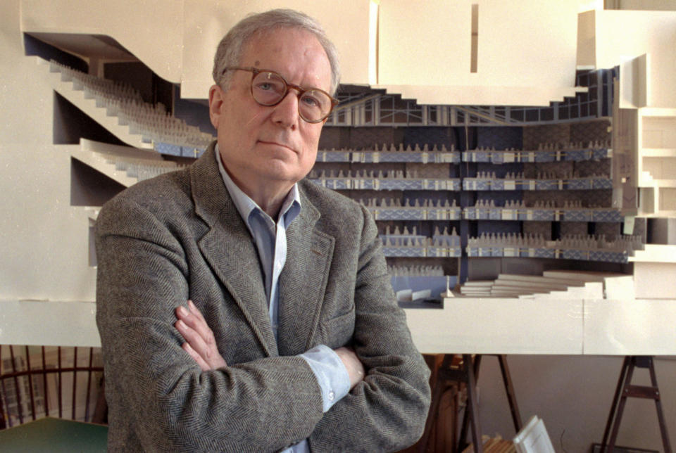 FILE - In this April 1991 file photo, architect Robert Venturi poses in his office in the Manayunk section of Philadelphia, with a model of a new hall for the Philadelphia Orchestra in background. Venturi, who turned austere modern design on its ear, ushering in postmodern complexity with the dictum "Less is a bore," has died. He was 93. His family released a statement on his firm’s website saying Venturi died at home in Philadelphia on Tuesday, Sept. 18, 2018, after a brief illness, and was surrounded by his wife and son. (AP Photo/George Widman, File)