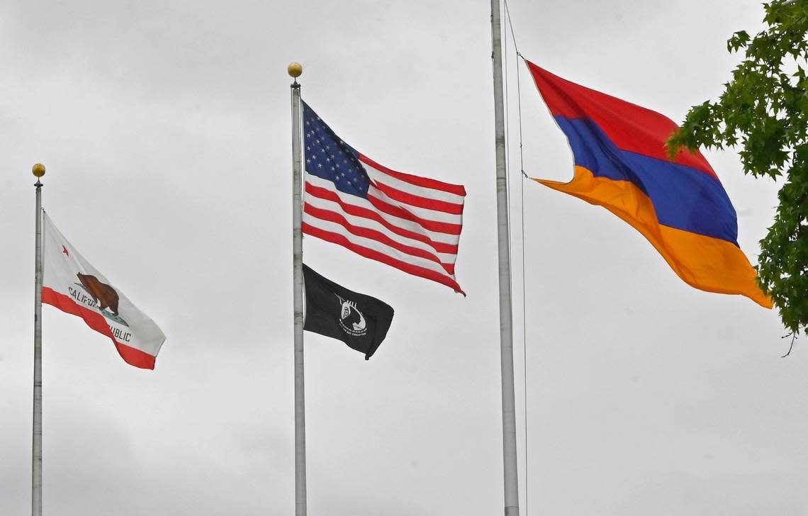 The Armenian flag, right, waves in the wind outside Fresno City Hall after a flag-raising ceremony in remembrance of the 1915 Armenian genocide, Wednesday, April 24, 2024 in Fresno.