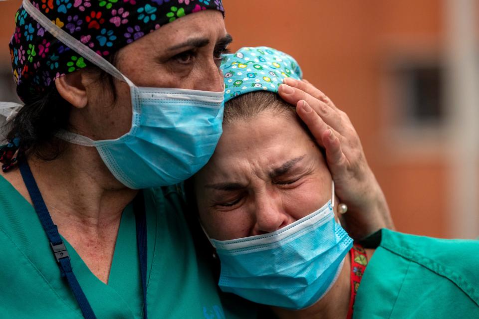 Health workers cry during a memorial for their co-worker who died from COVID-19 on April 10, 2020.