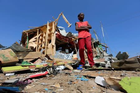 A Somali boy stands outside their shop destroyed near the scene of a suicide bomb explosion at the Wadajir market in Madina district of Somalia's capital Mogadishu February 19, 2017. REUTERS/Feisal Omar