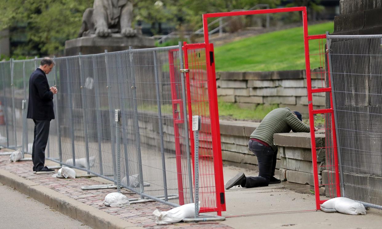 People pray inside and outside of the barricade fencing surrounding the Summit County Courthouse during a vigil held by Love Akron on Tuesday.