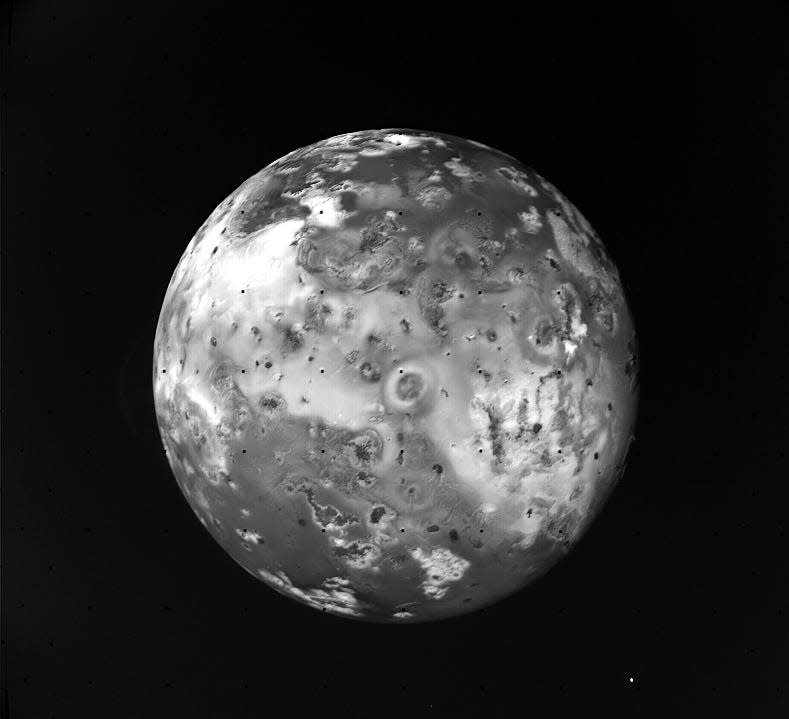 black and white photo of Jupiter's moon Io showing pock marks and divets all over this alien world