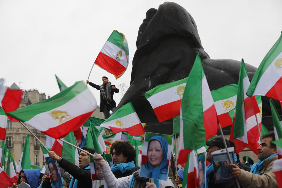 Demonstrators carry posters of Maryam Rajavi, the leader of the National Council of Resistance of Iran, and wave Iranian flags during a protest in Paris, Friday Feb.8, 2019 as Iran marks the 40th anniversary of its Islamic Revolution. (AP Photo/Francois Mori)