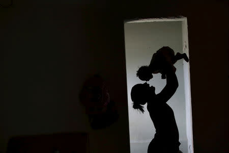 Rosana Vieira Alves, sostiene a su hija de cuatro meses, Luana Vieira, quien nació con microcefalia en su casa en Olinda, Brasil, feb 3, 2016. REUTERS/Ueslei Marcelino/File Photo