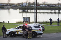 Law enforcement officers man a road block leading to a staging area during the investigation of a plane crash in Trinity Bay in Anahuac, Texas, Saturday, Feb. 23, 2019. A Boeing 767 cargo jetliner heading to Houston with a few people aboard disintegrated after crashing Saturday into the bay east of the city, according to a Texas sheriff. (Brett Coomer/Houston Chronicle via AP)