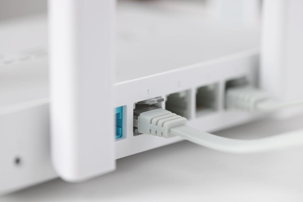 Network cable is plugged into socket of access point closeup. Fast internet concept