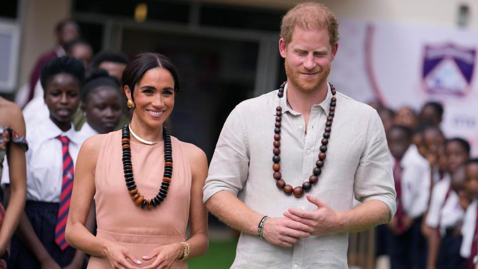 Harry and Meghan smile as they visit school in Nigeria