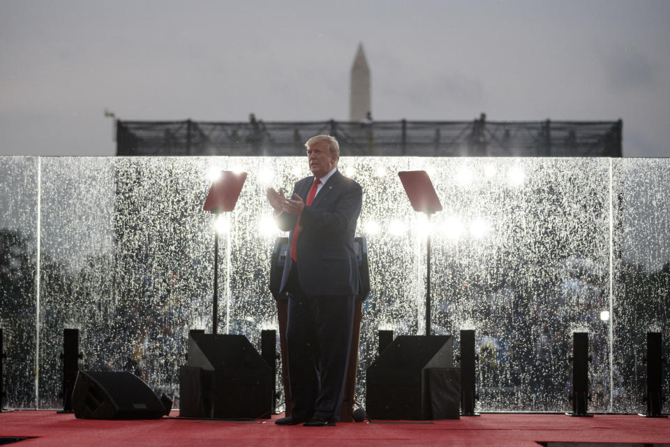 President Donald Trump applauds as he speaks in the rain behind glass during an Independence Day celebration in front of the Lincoln Memorial, Thursday, July 4, 2019, in Washington. The Washington Memorial is in the background. (AP Photo/Carolyn Kaster)