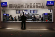 A fan looks at the menu at a concession stand as teams warm up before an NFL wild-card playoff football game between the Buffalo Bills and the Indianapolis Colts at Bills Stadium Saturday, Jan. 9, 2021, in Orchard Park, N.Y. (AP Photo/Jeffrey T. Barnes)