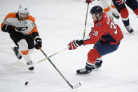 Washington Capitals right wing Anthony Mantha (39) and Philadelphia Flyers center Claude Giroux (28) vie for the puck during the first period of an NHL hockey game Tuesday, April 13, 2021, in Washington. The Capitals won 6-1. (AP Photo/Nick Wass)