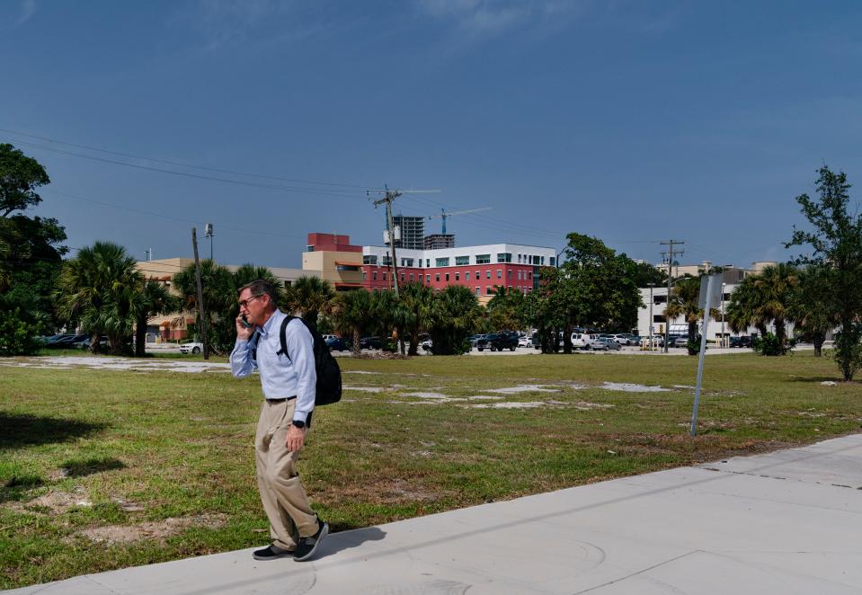 A man passes by an empty lot in the 900 block of Evernia Street in West Palm Beach, in 2021. The land could be the site of a University of Florida graduate campus.