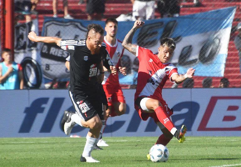 Nicolás Dematei se lleva la pelota ante la marca de Santiago González durante el partido por el segundo ascenso a la primera división disputado en Córdoba