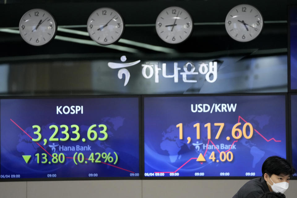 A currency trader watches computer monitors near the screens showing the Korea Composite Stock Price Index (KOSPI), left, and the foreign exchange rate between U.S. dollar and South Korean won at the foreign exchange dealing room in Seoul, South Korea, Friday, June 4, 2021. Asian shares mostly slipped Friday, dragged lower by a decline in technology stocks on Wall Street. (AP Photo/Lee Jin-man)