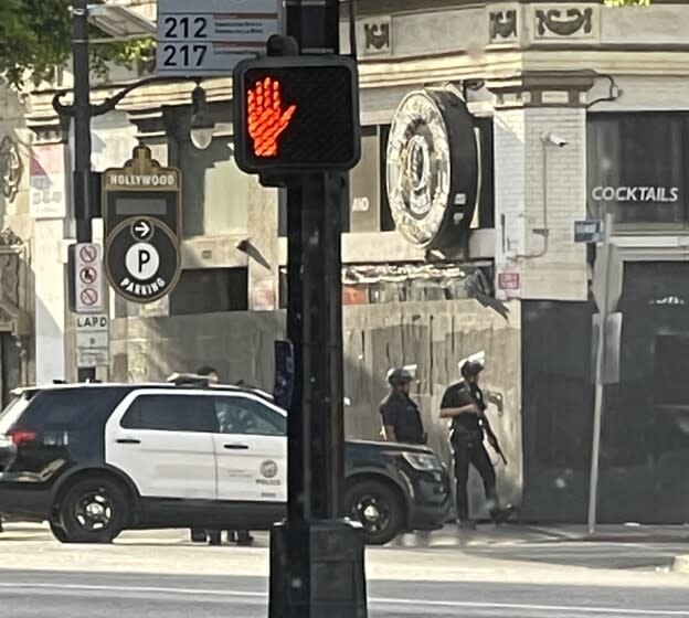 LAPD officers with guns drawn July 31 on Hollywood Blvd. after a suspect fired shots from an apartment.